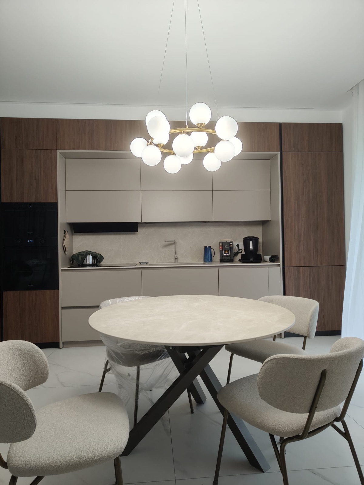 Tavolo rotondo davanti alla cucina in noce, realizzazione Molitierno Arredamenti