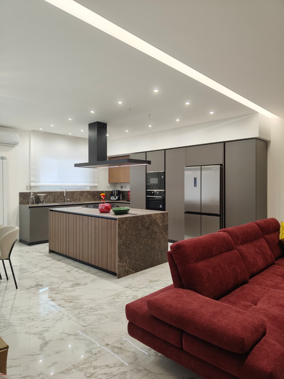 Cucina con isola alle spalle del divano, realizzazione Molitierno Arredamenti